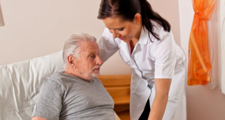 nurse assisting elderly man
