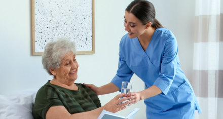 nurse giving water to the elderly woman