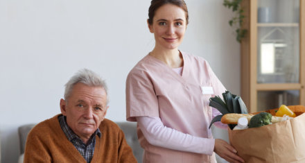 elderly man and nurse looking at the camera