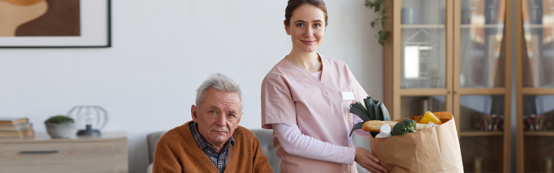 elderly man and nurse looking at the camera