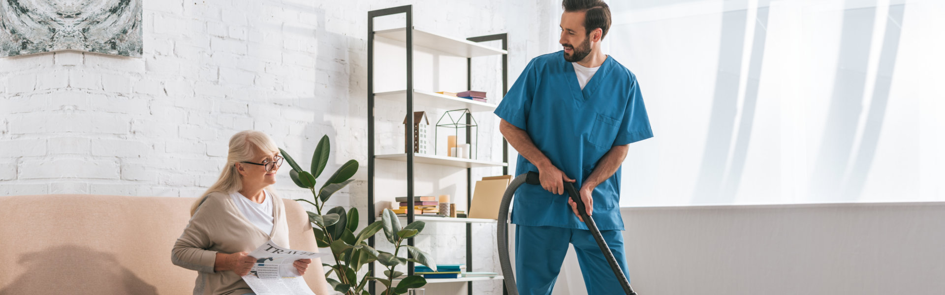 nurse cleaning the living room and elderly woman sitting