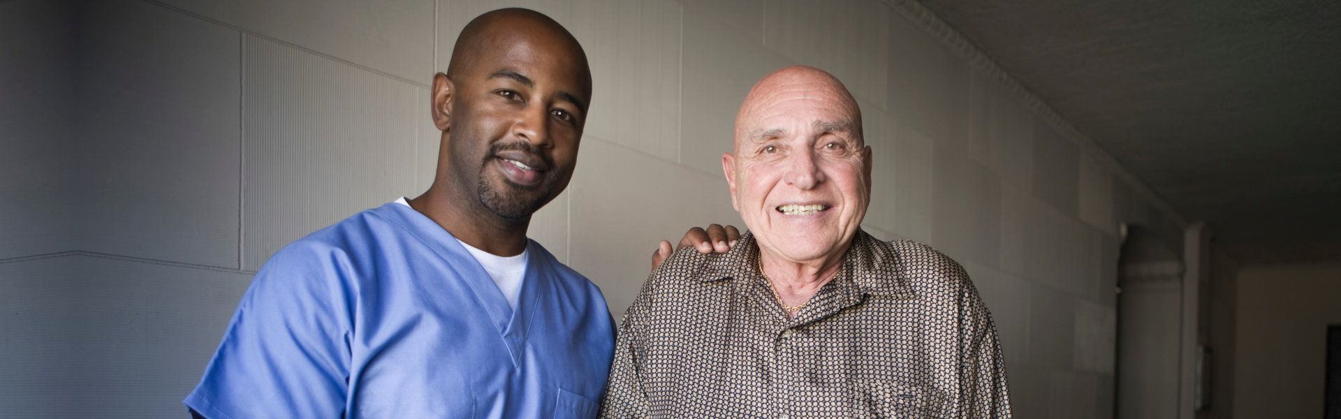 elderly man and nurse looking at the camera