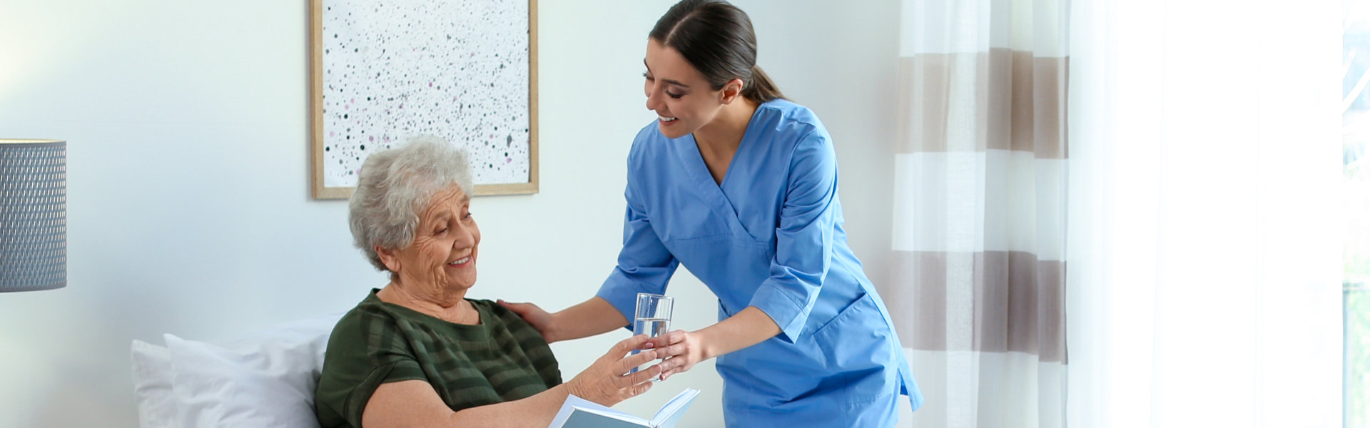 nurse giving water to the elderly woman